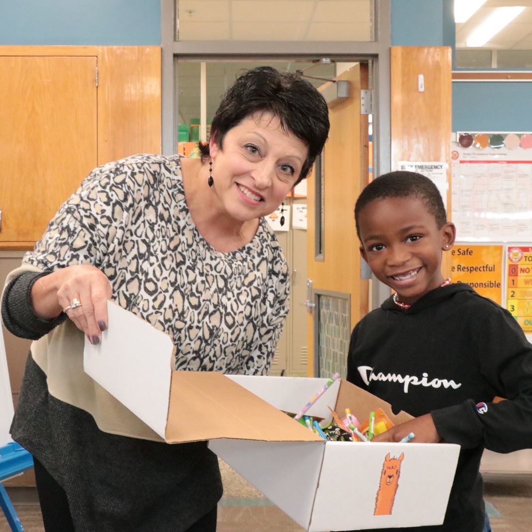  Rhonda Archer shares a box of incentives with a student